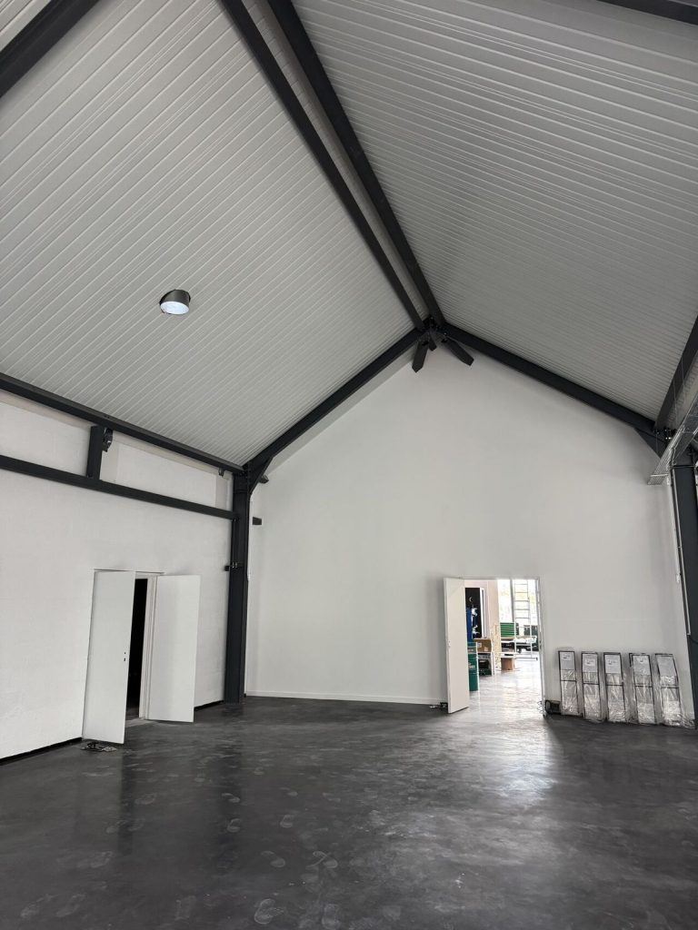 L'intervention multilots a mobilisé toute l'expertise de l'entreprise : cloisons et doublages pour sculpter les espaces, habillage tôle aux couleurs emblématiques vert Kawasaki et orange KTM, sols haute résistance, équipements sanitaires et serrurerie de sécurisation.