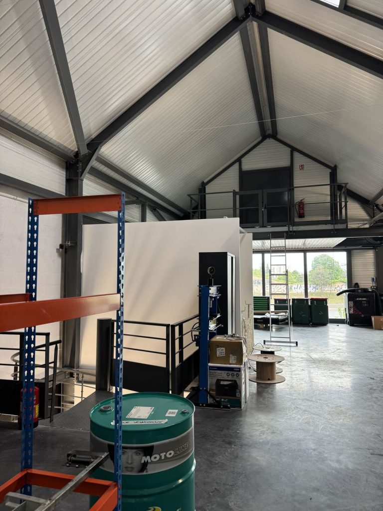 L'intervention multilots a mobilisé toute l'expertise de l'entreprise : cloisons et doublages pour sculpter les espaces, habillage tôle aux couleurs emblématiques vert Kawasaki et orange KTM, sols haute résistance, équipements sanitaires et serrurerie de sécurisation.